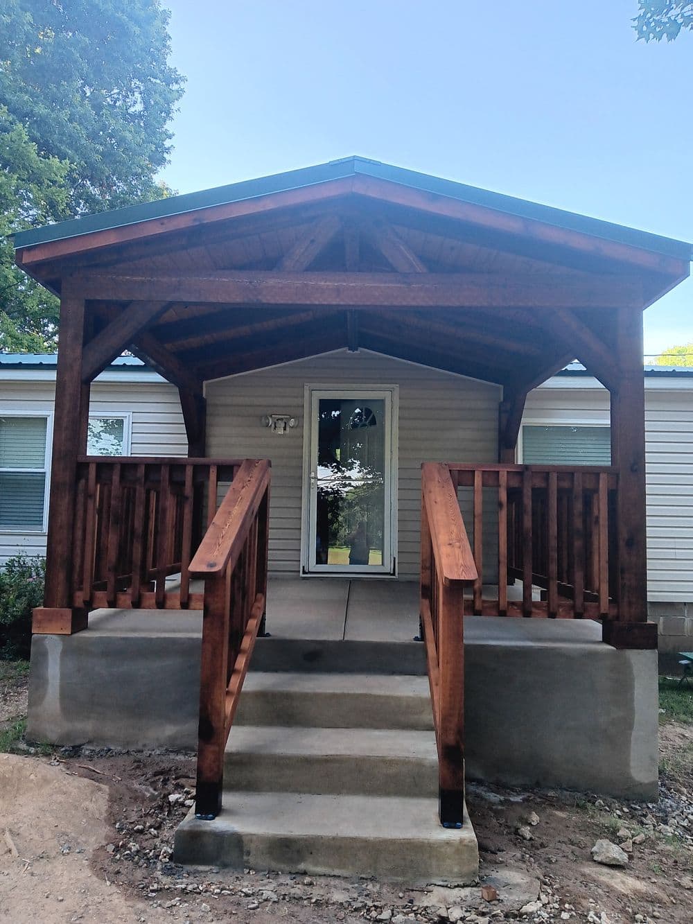 Newly built wooden porch with ramp, offering accessibility to a home exterior.